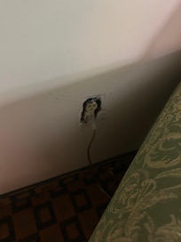 Missing cover plate next to couch.