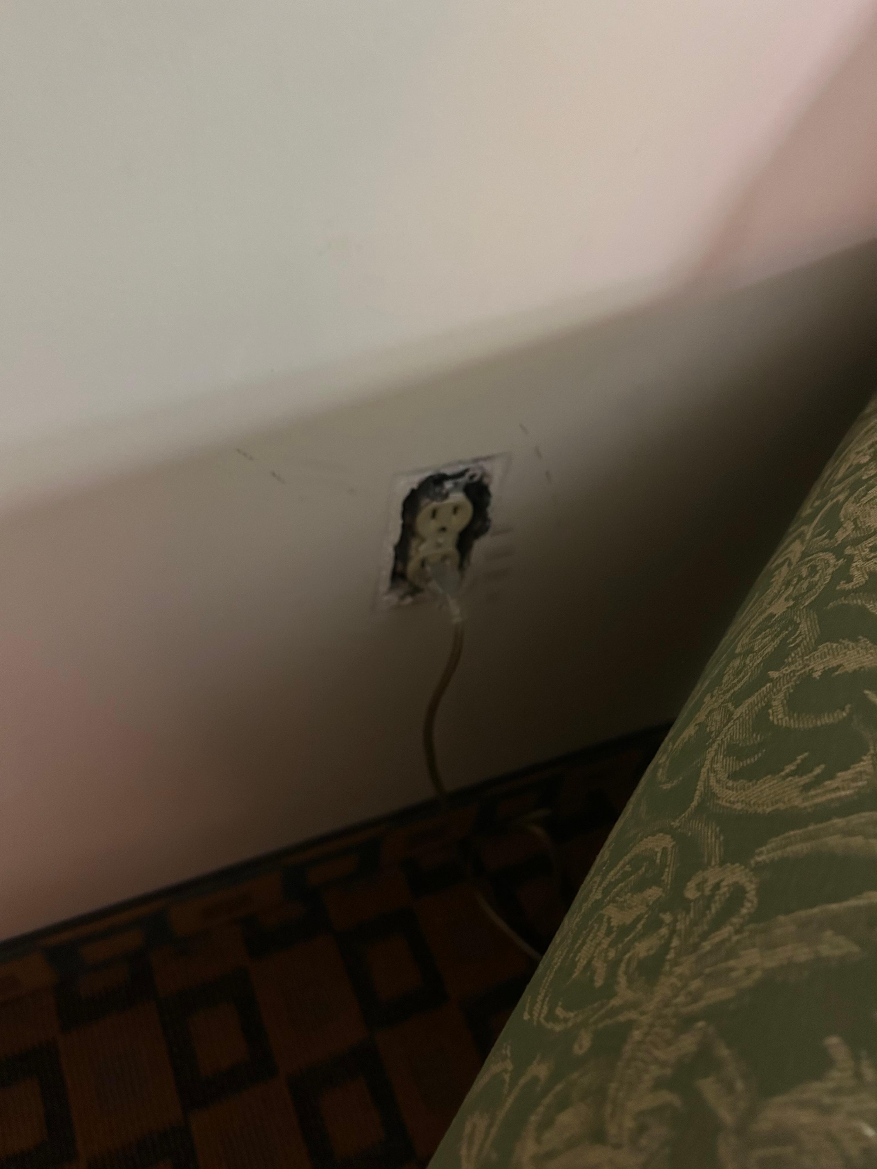 Missing cover plate next to couch.