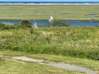 A sailboat heads down a channel,