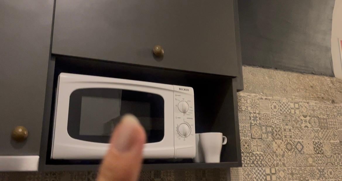 Microondas e armários com alguns utensílios 