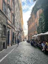Typical Roman street with cobbled road and restaurants