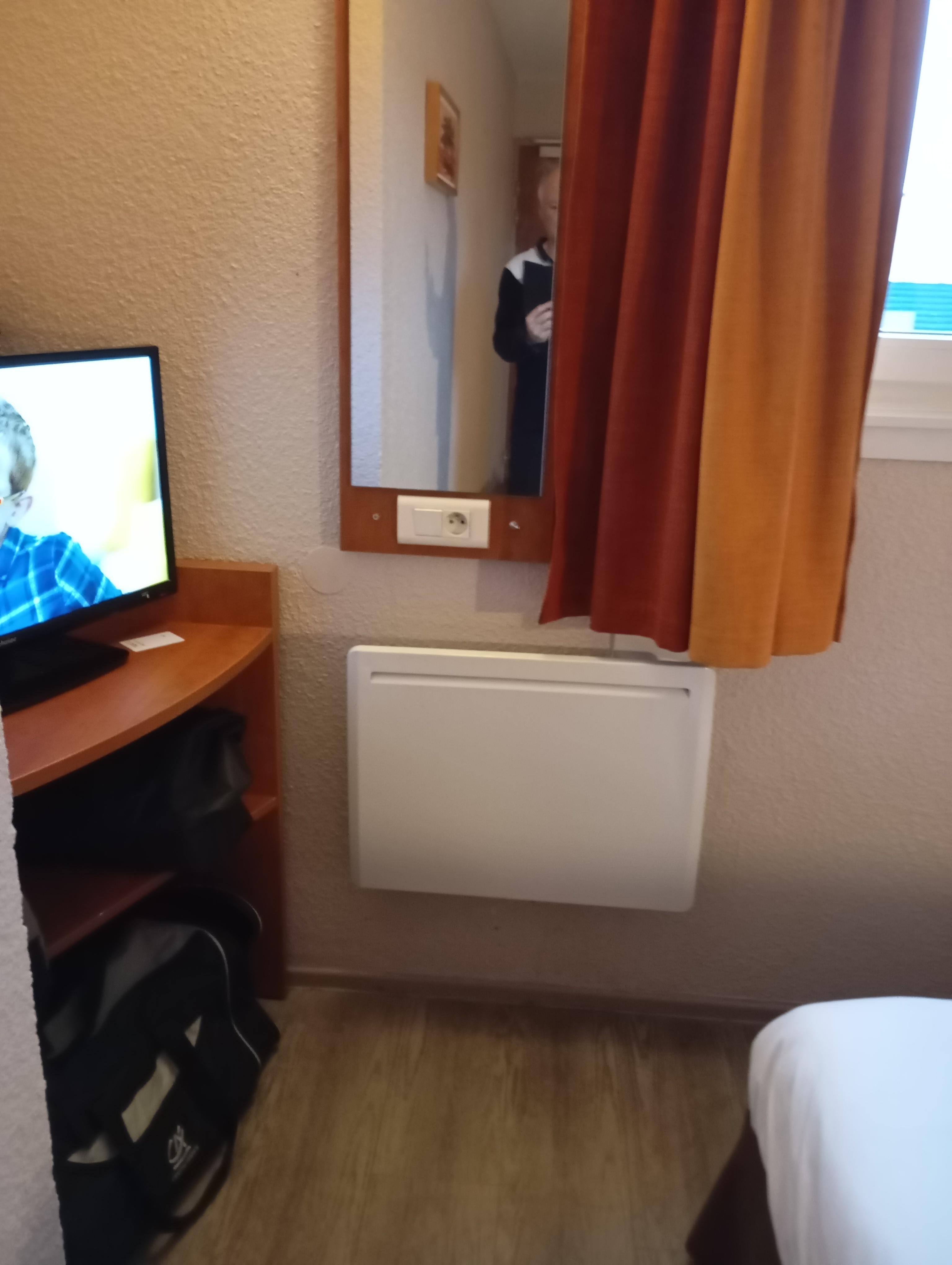 prise de courant et rideau au dessus du radiateur 