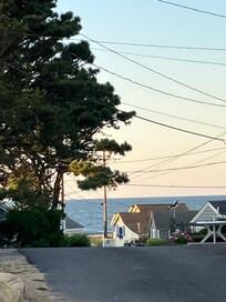 Standing in front of cottage looking out at ocean and toward the beach.