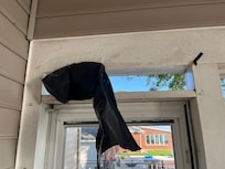 Window in the screened porch missing and half covered over by black plastic.