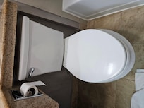 Toilet paper dispenser positioned where it's inaccessible while seated on toilet