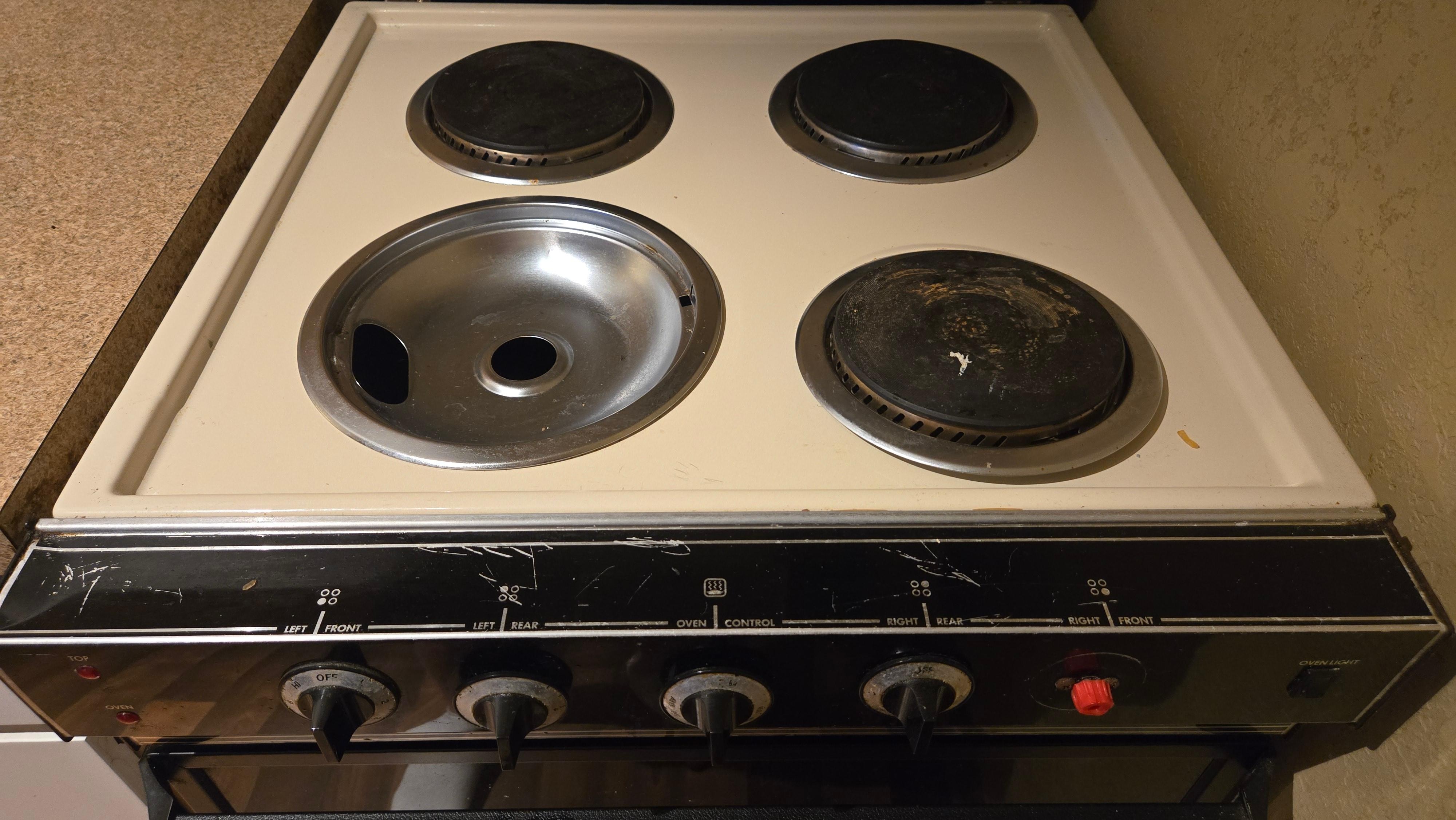 dirty rusty stove with one burner missing