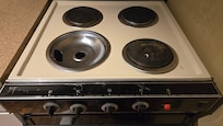 dirty rusty stove with one burner missing