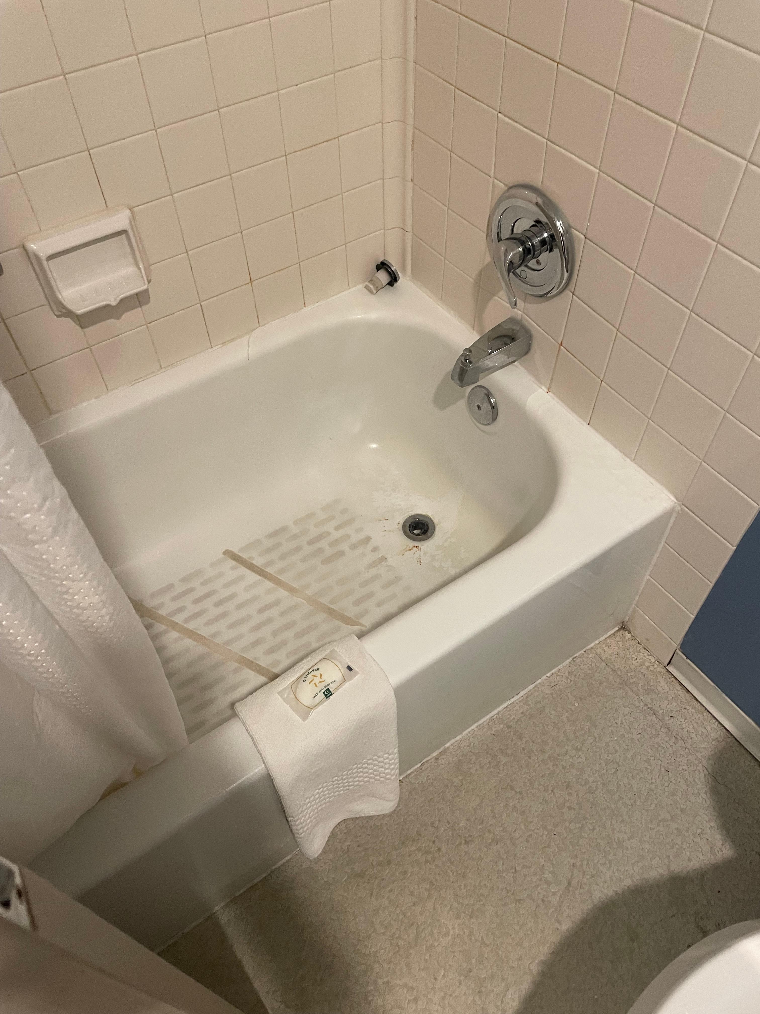 Shower tub with dirt all over the base and grime everywhere