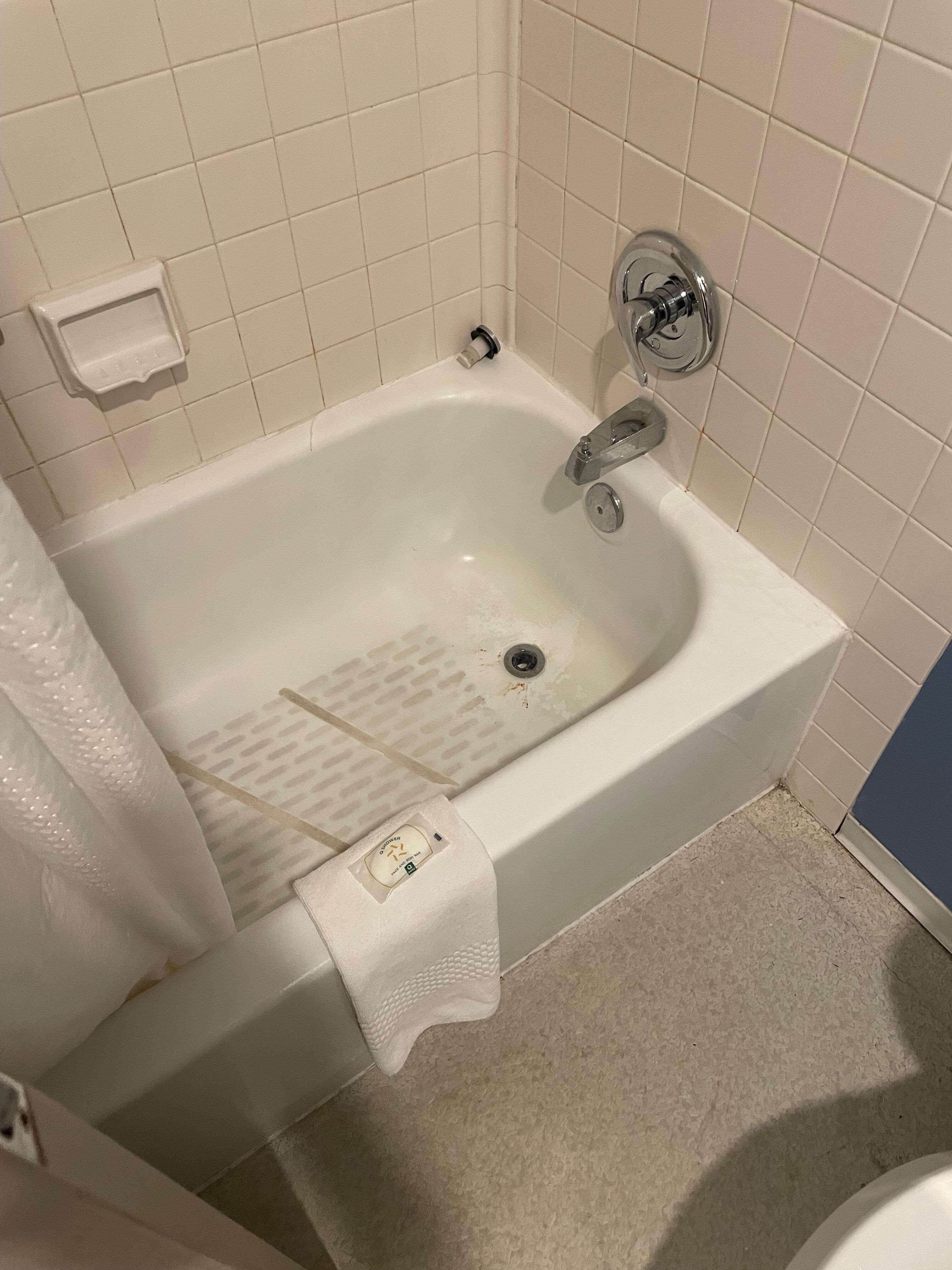 Shower tub with dirt all over the base and grime everywhere