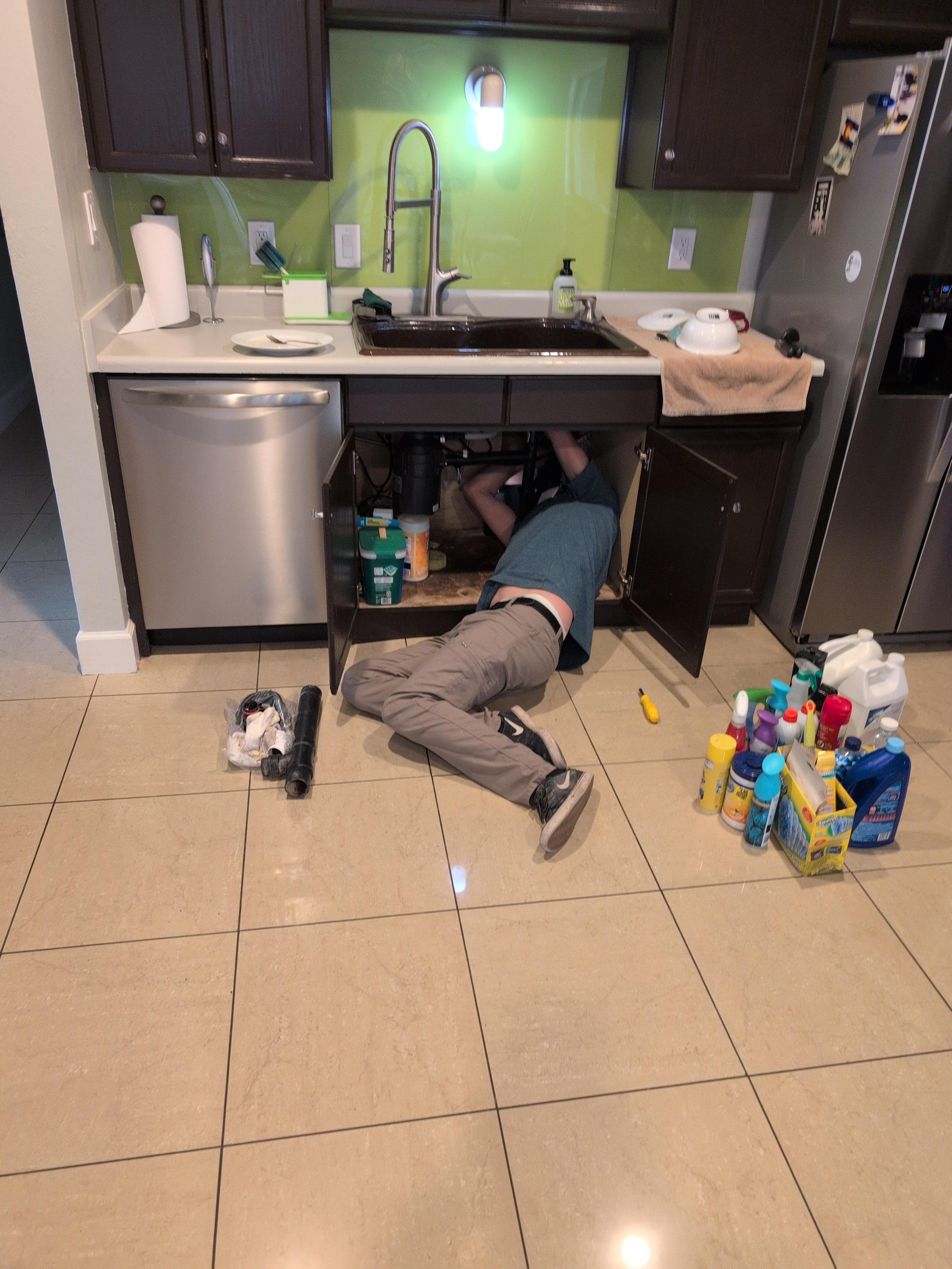 Wide Angle Shoot of Plumber Fixing Kitchen Sink