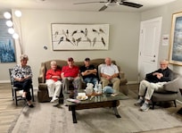 Some of our group in the living area. Tv on stair wall to left of couch.