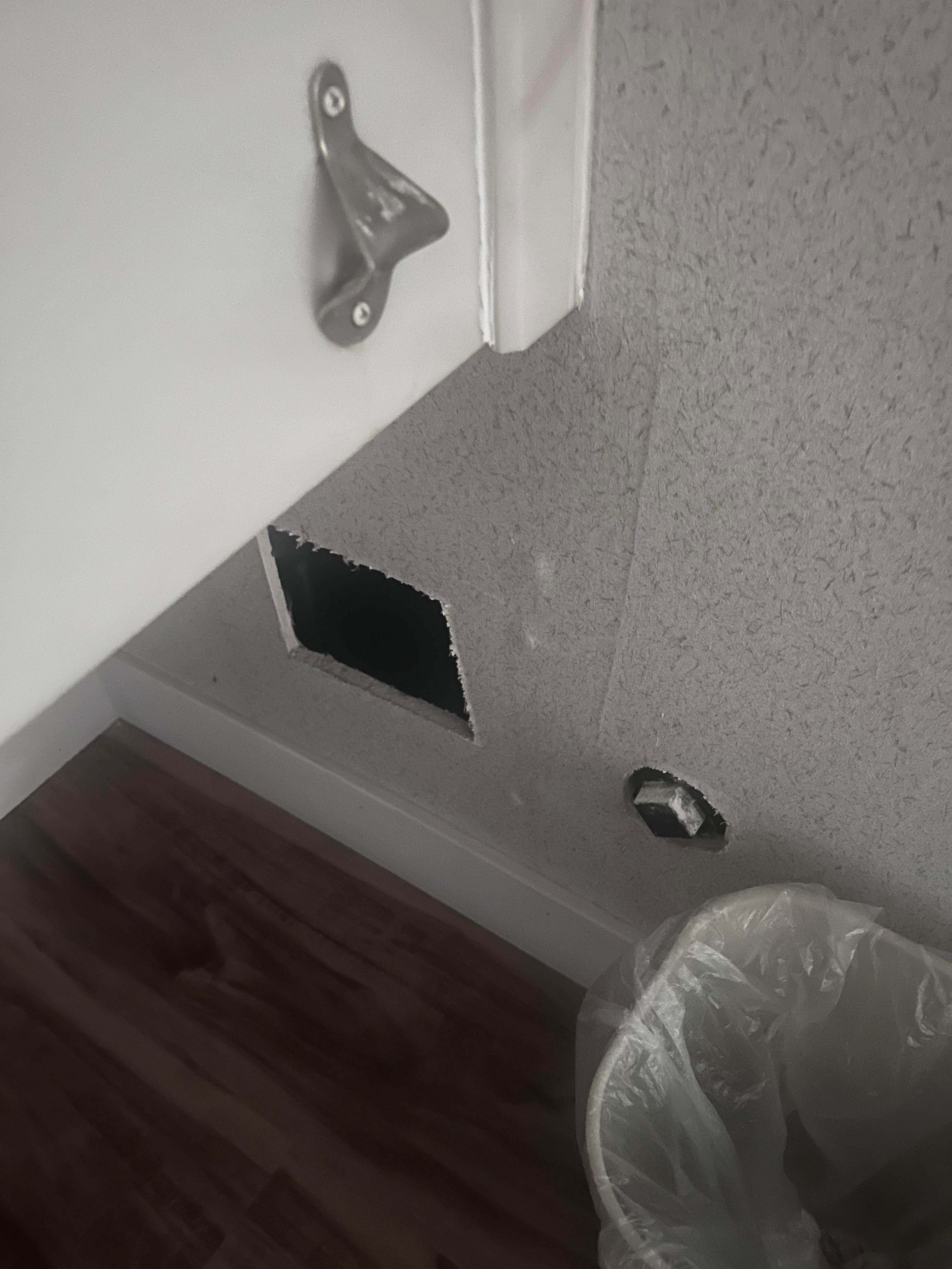 There was a hole in the wall covered with a trash can.
