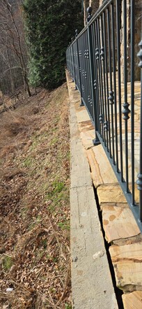 Picture shows the retaining wall slowly coming out from the patio. The patio is no longer supported. House supports rest on the patio also. No structural support.