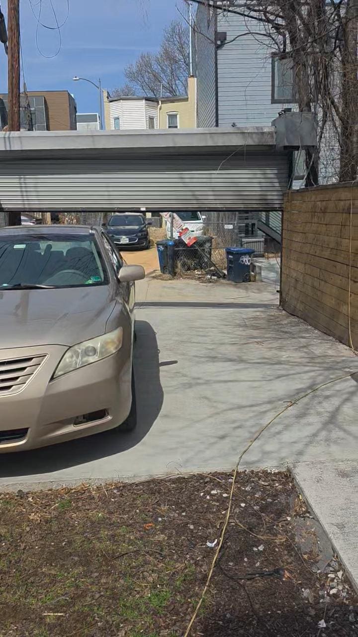 Garage door not opening for more than a small car.  Also see the Garbage in the back ground.  Not a nice area.