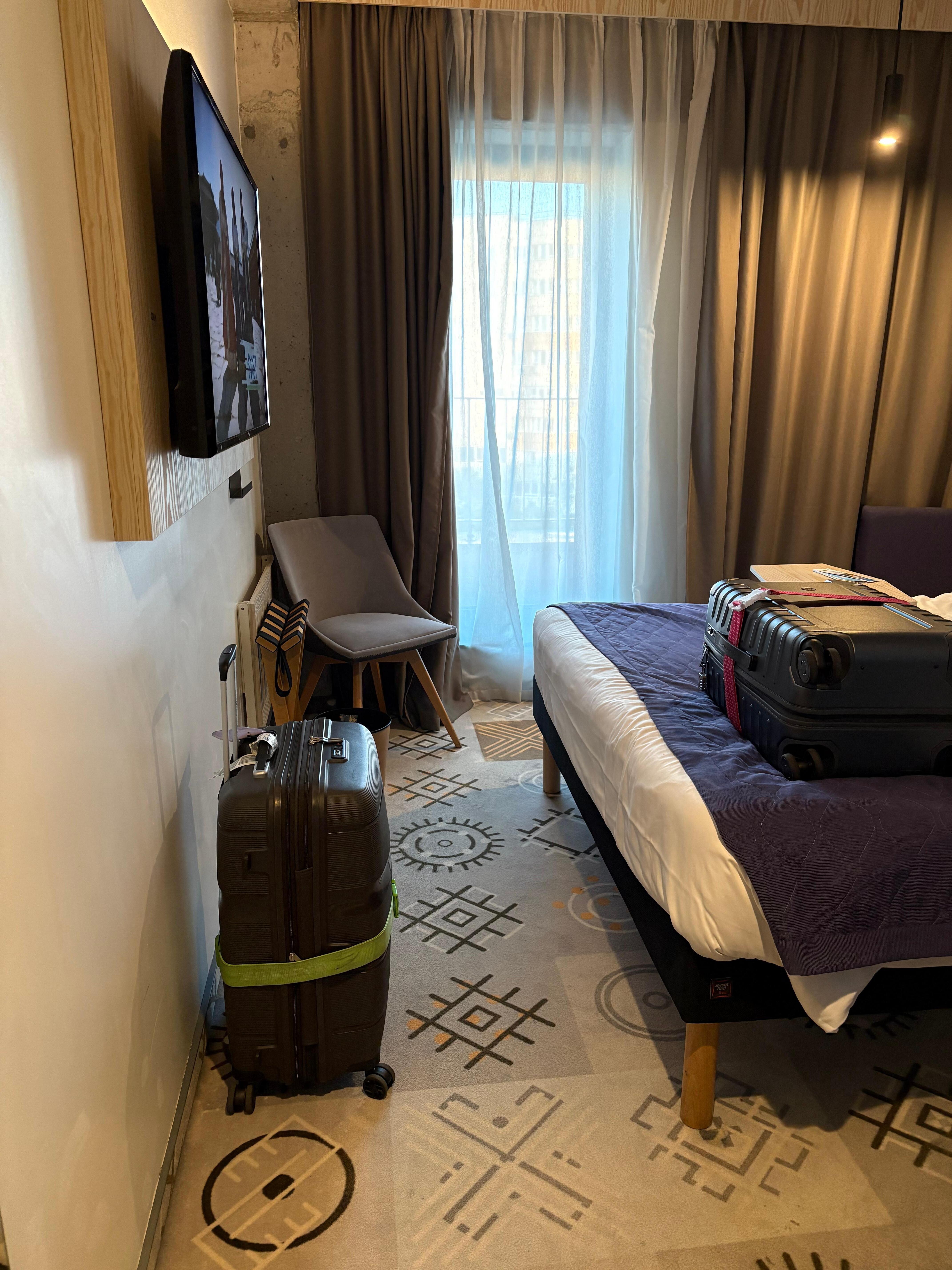 Space between bed and wall. This is a medium sized suitcase in picture 