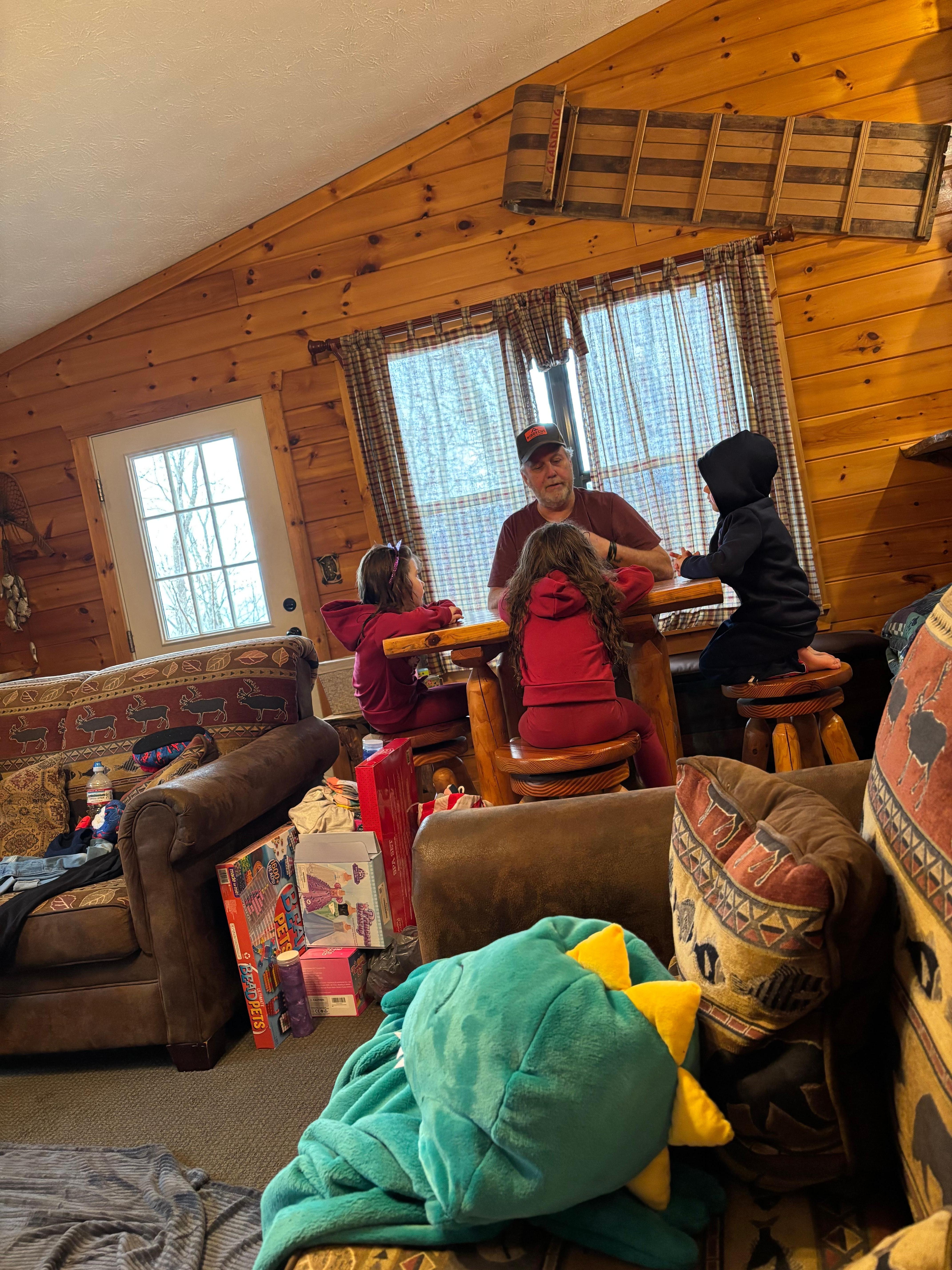 Grandchildren playing checkers with their poppop. There were lots of games for the kids to play. Supplied by the host. 