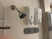 Shower head, shampoo and conditioner.