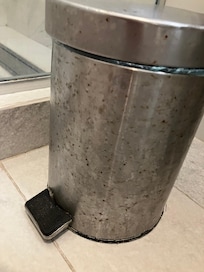 Rusty broken garbage container in bathroom