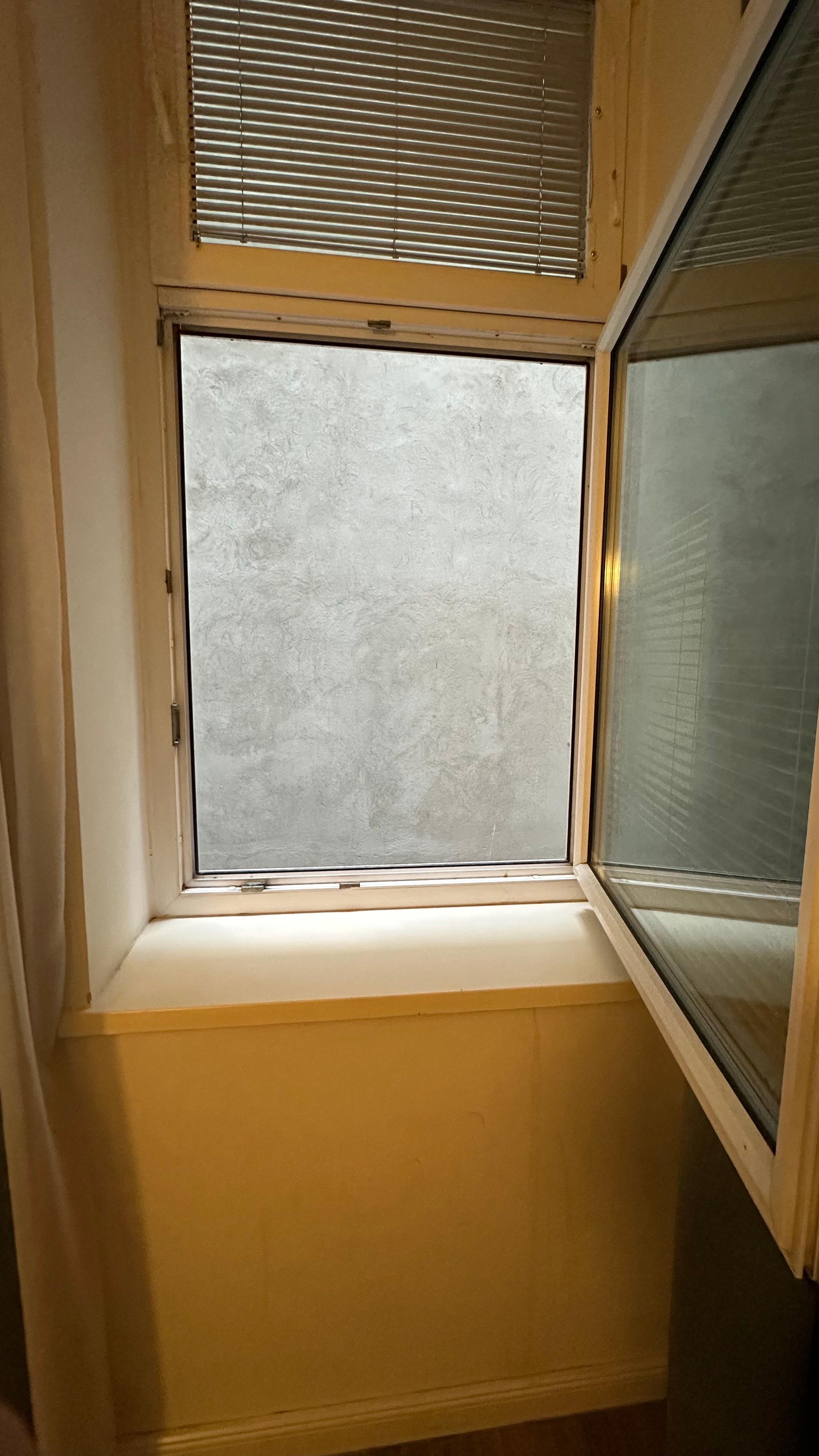 Blick aus dem kleinen Fenster - eine graue Wand