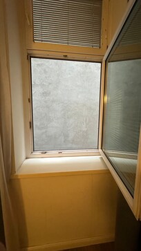 Blick aus dem kleinen Fenster - eine graue Wand