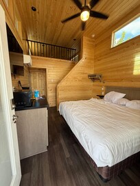 The corner of the bed is right inside the door.