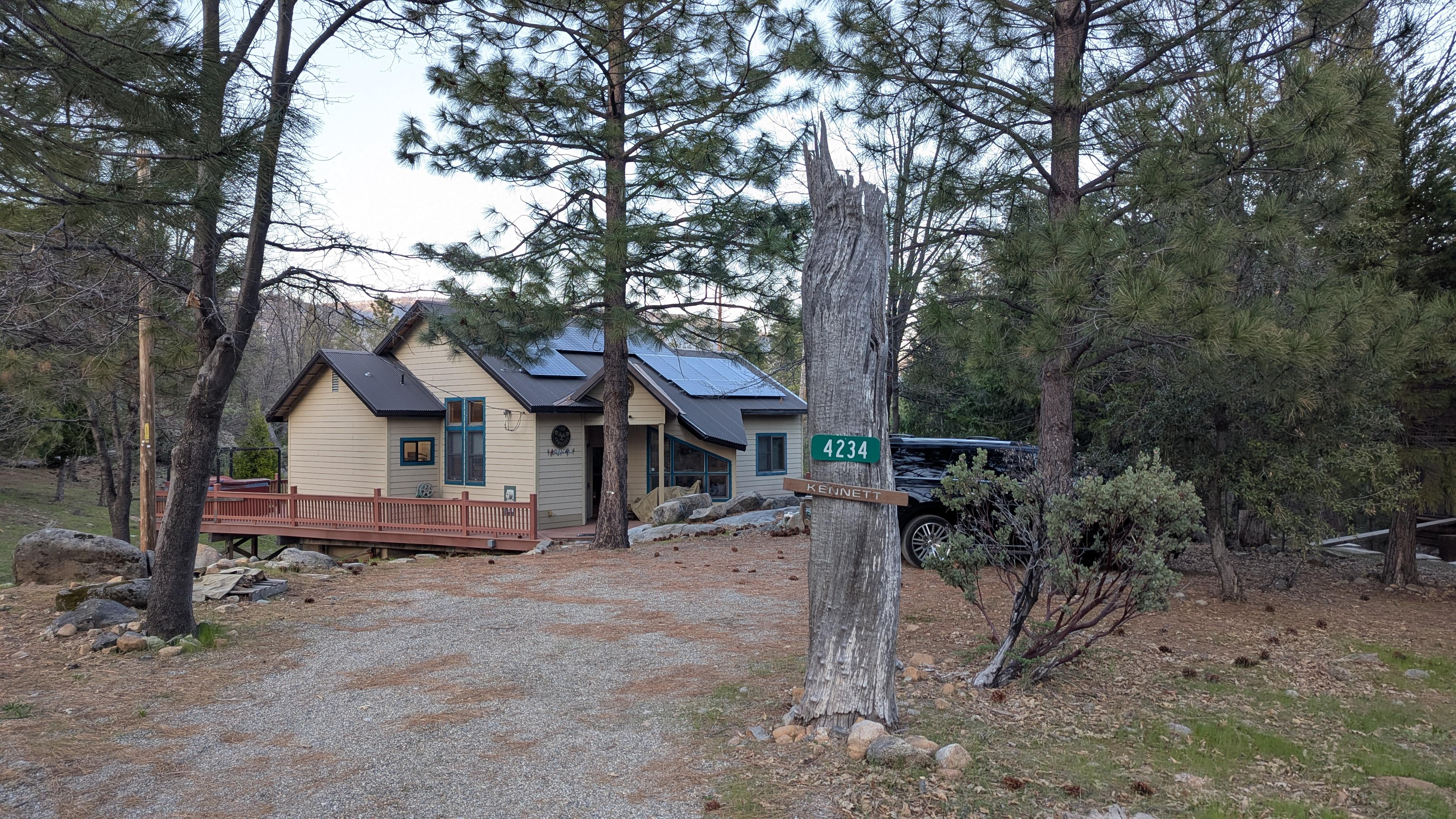 The house is set in a quiet forested neighborhood.