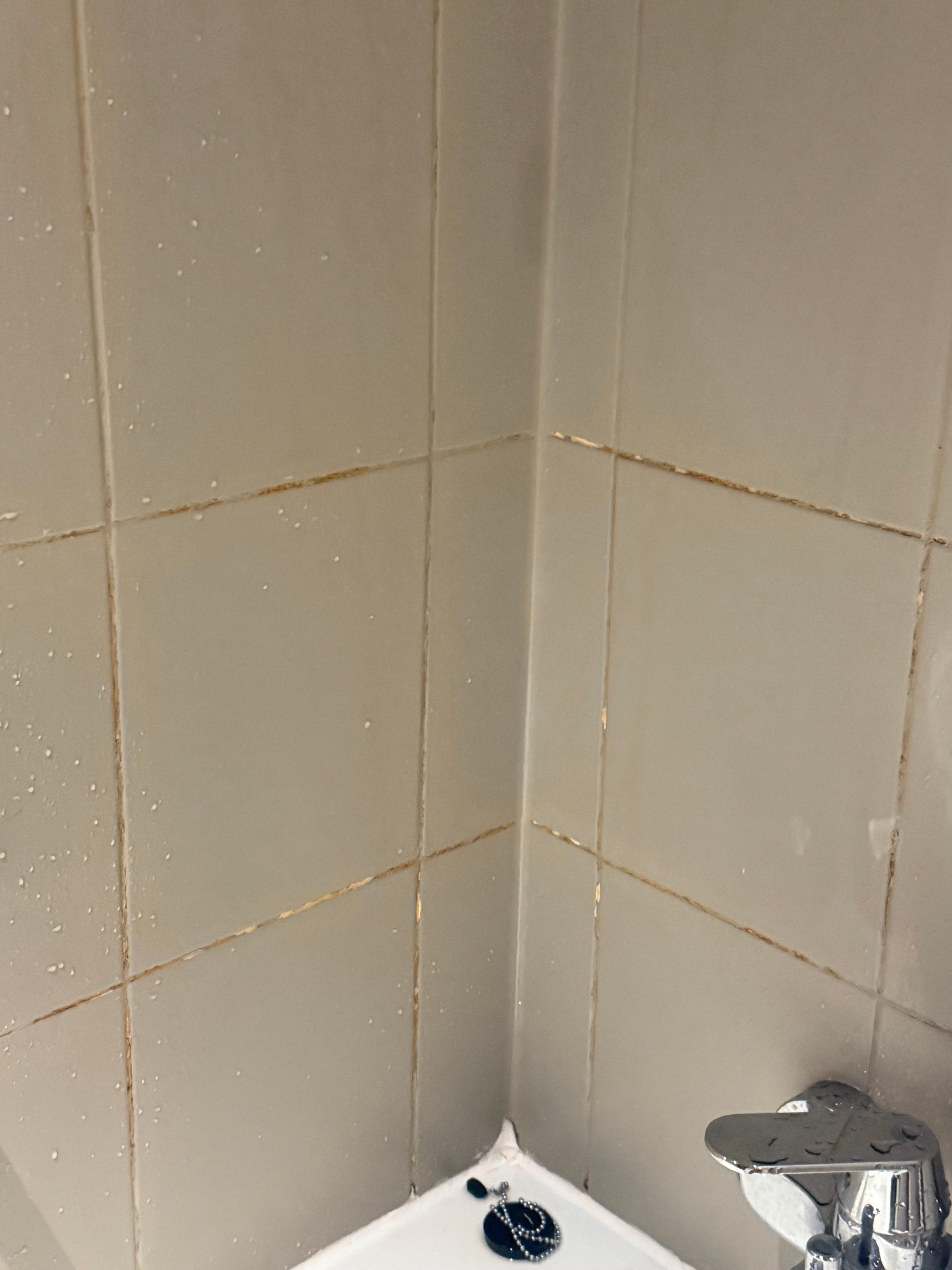 Dirty build up on wall on tub of bathroom 