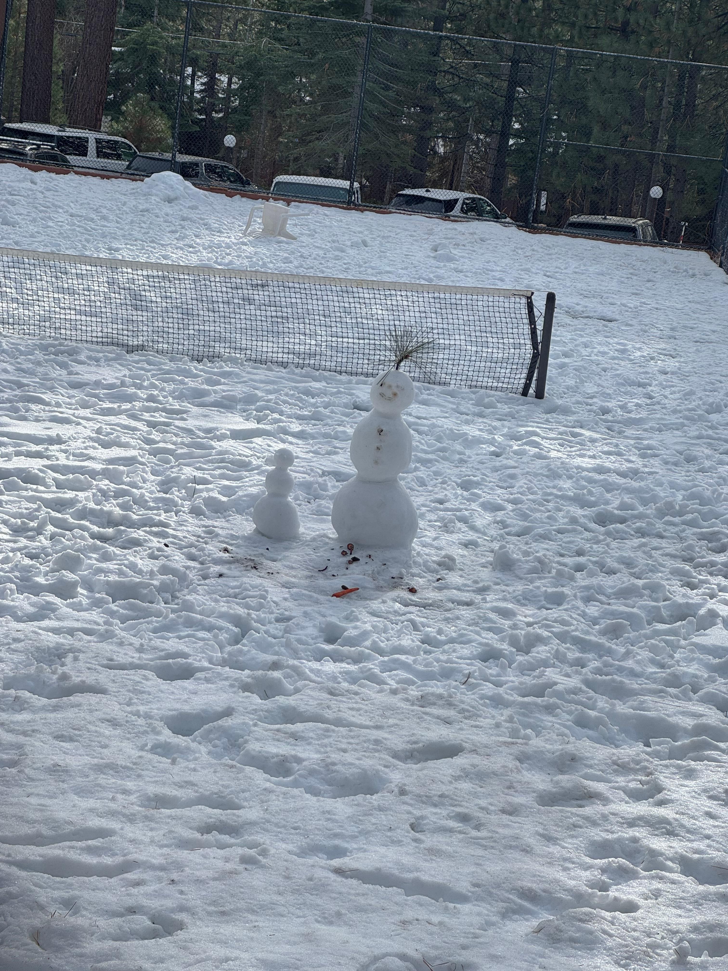 Kids they a snowman on the tennis court 