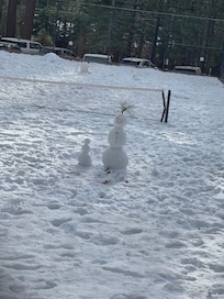 Kids they a snowman on the tennis court