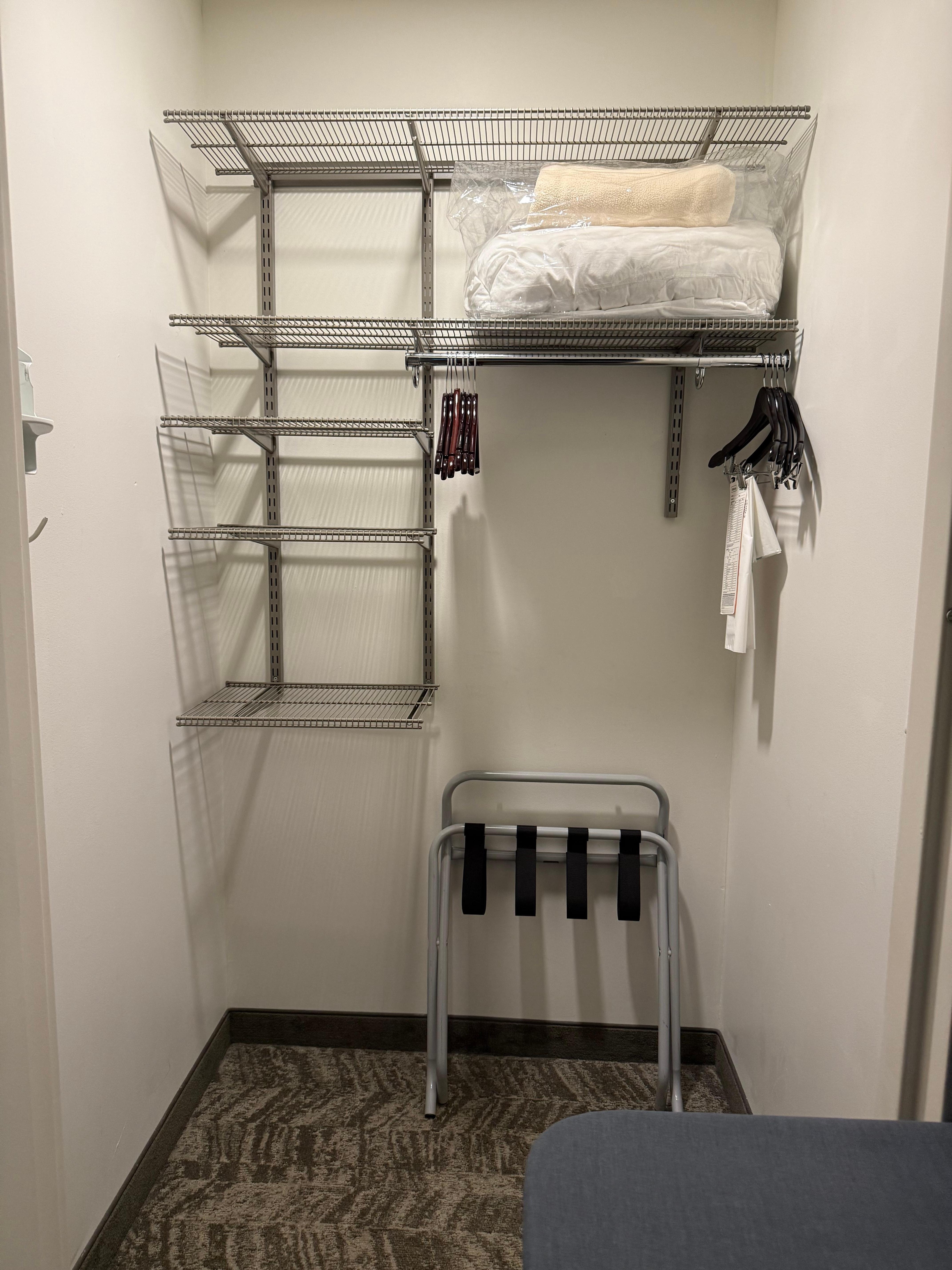 Walk in closet for organizing clothes and storing luggage.
