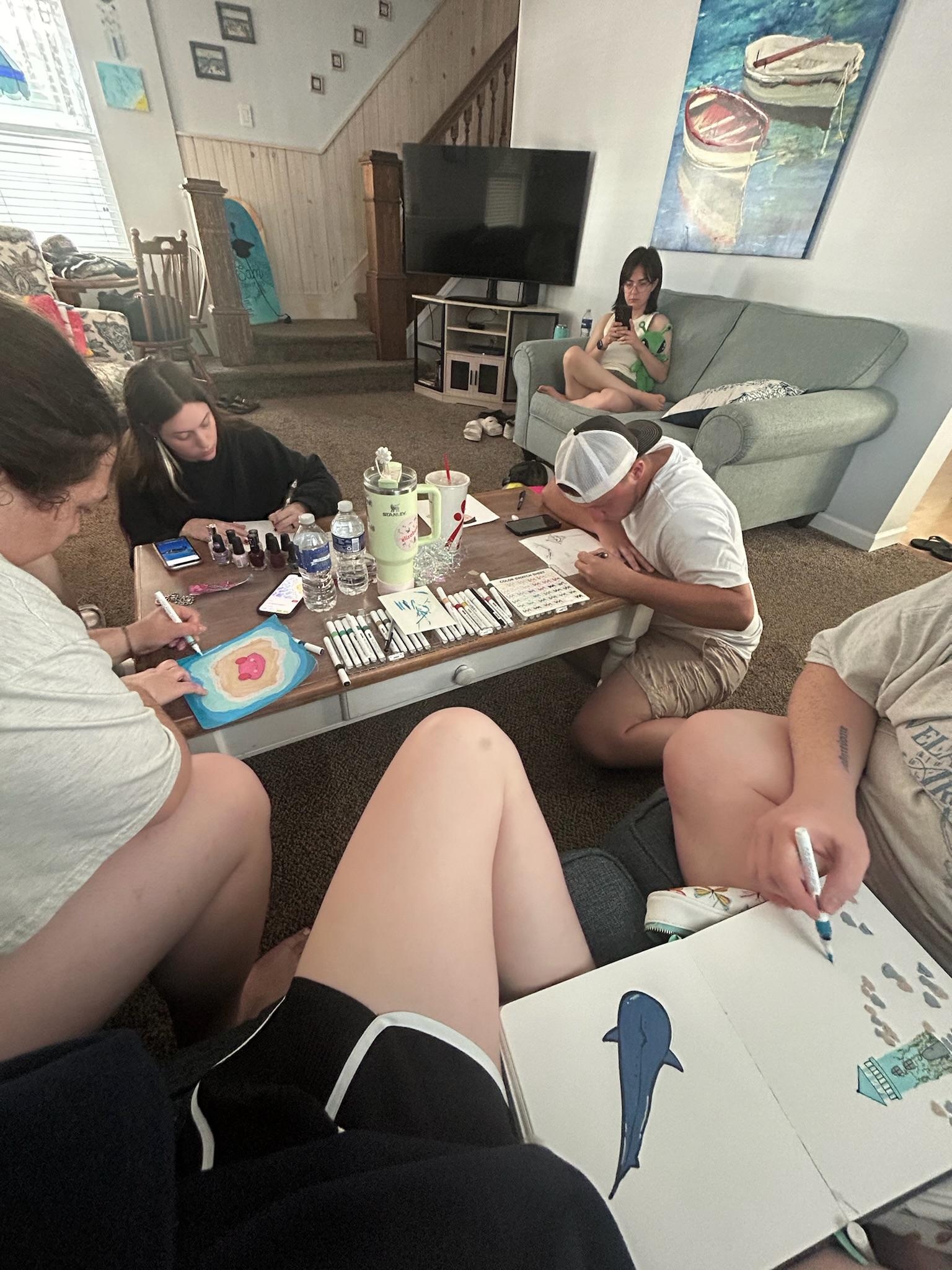 The teens doing beach inspired artwork. 