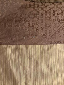 Cigarette burns on top portion of bed cover (bed 1)