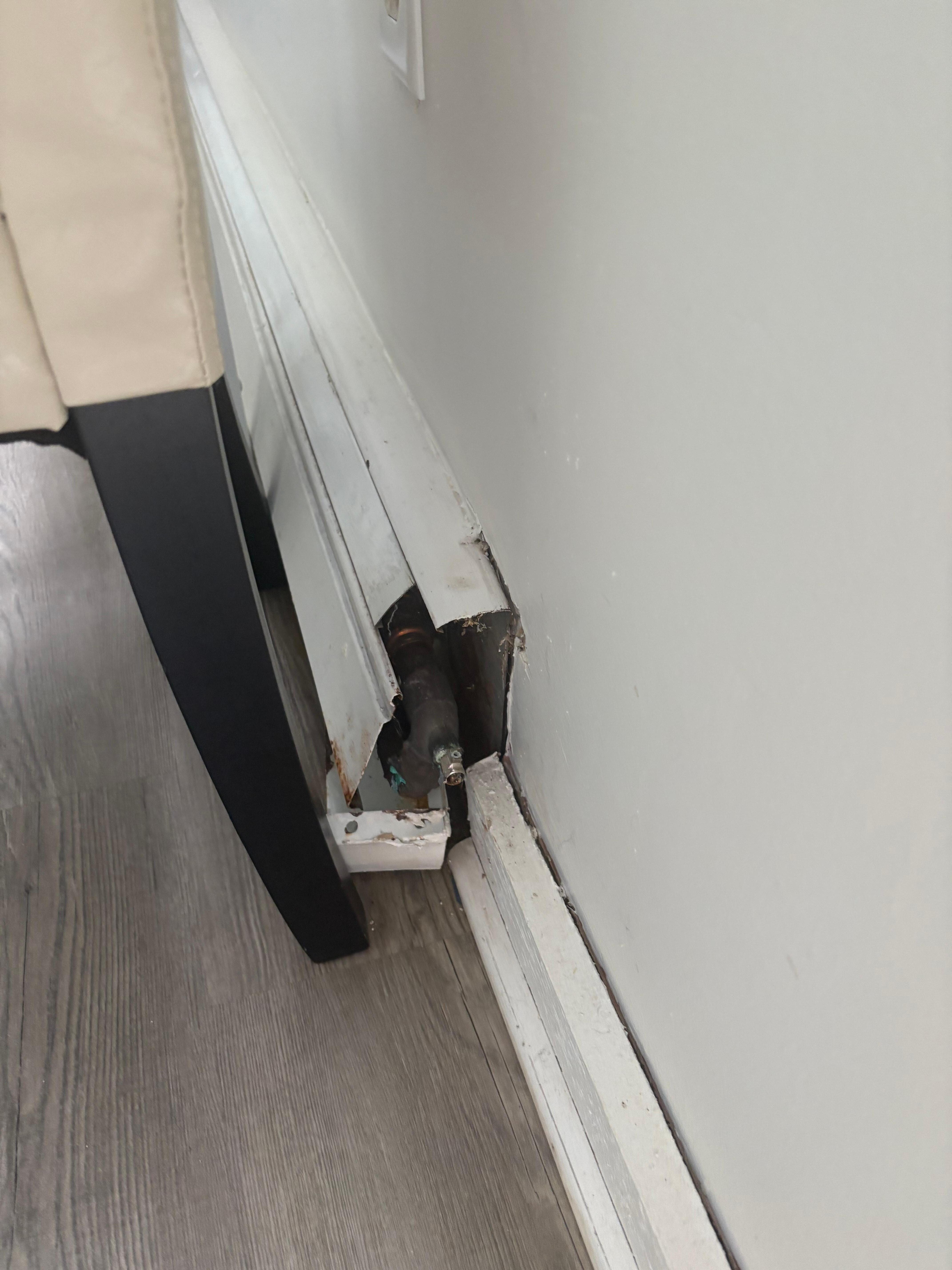 One of many broken baseboard heaters- this one was broken on the side, some had bottom broken with jagged metal edges hanging out.
