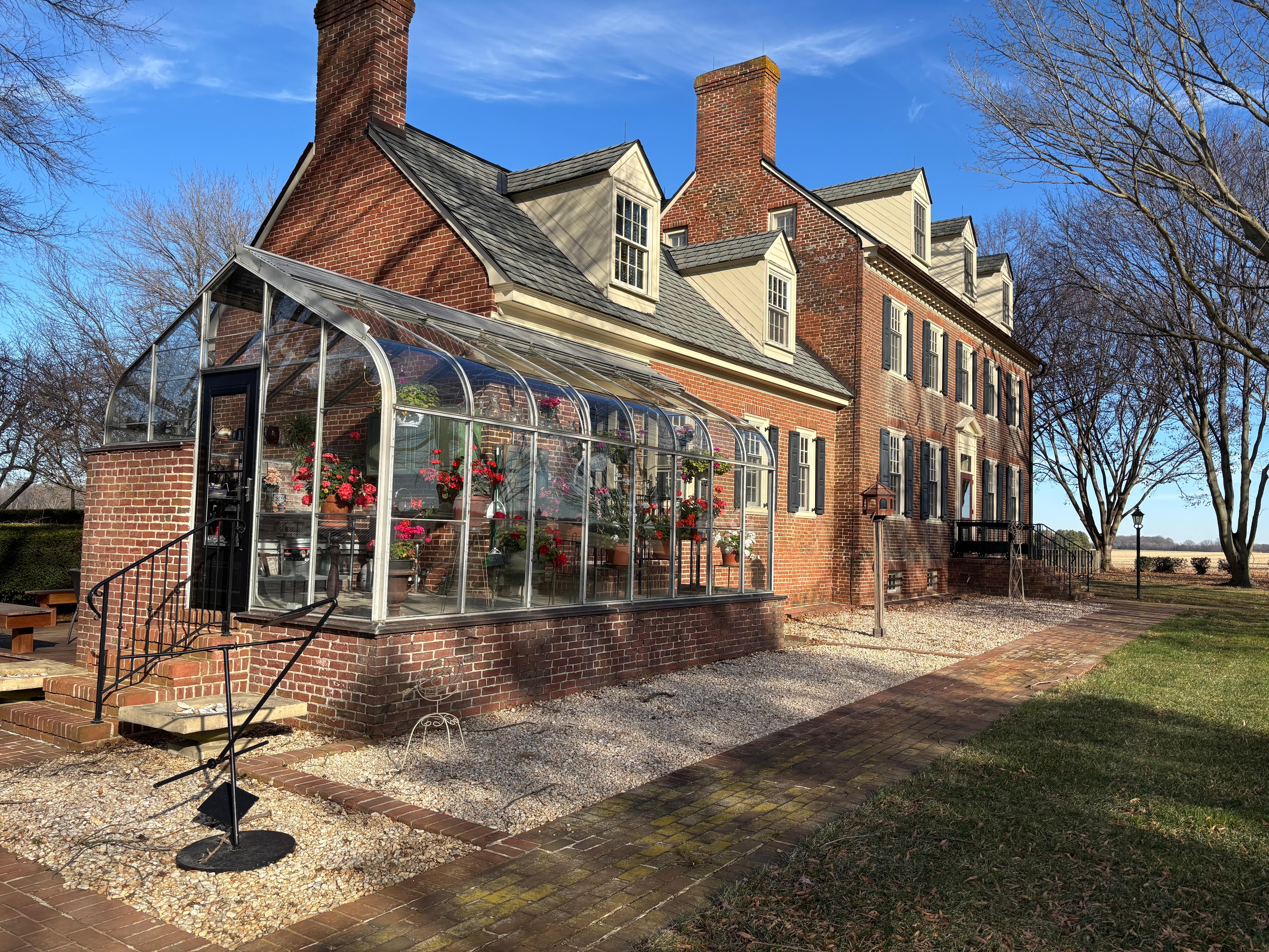 Exterior with greenhouse, which was full of blooming geraniums.