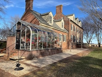Exterior with greenhouse, which was full of blooming geraniums.