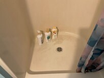 The shower has a couple inches of water and shower curtain dirty