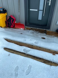 porch with 3 inches of ice covered by thin layer of snow