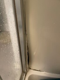 Hole in the upstairs shower - patched with spackle on the other side.