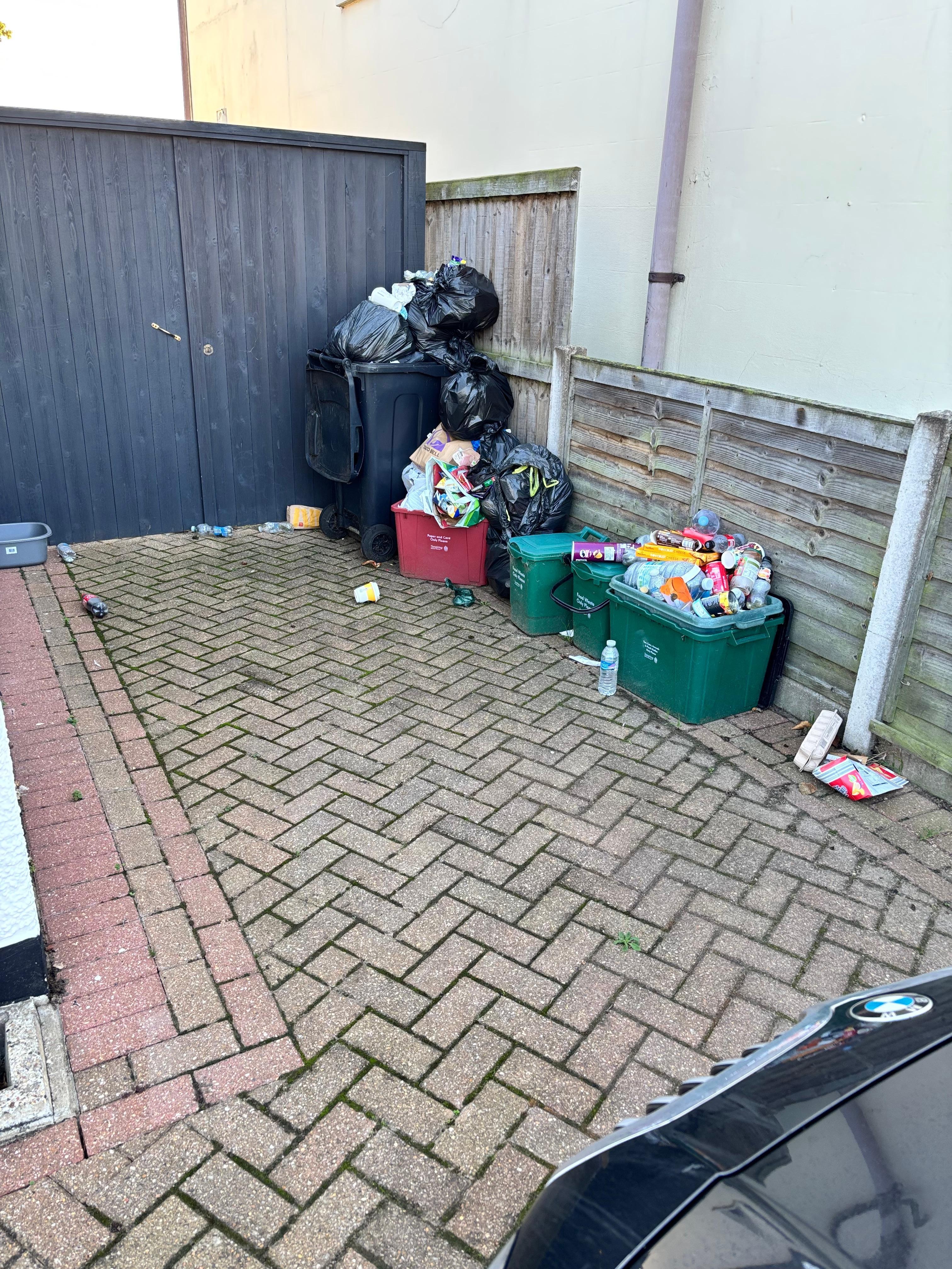 Piles of rubbish at the side of the house
