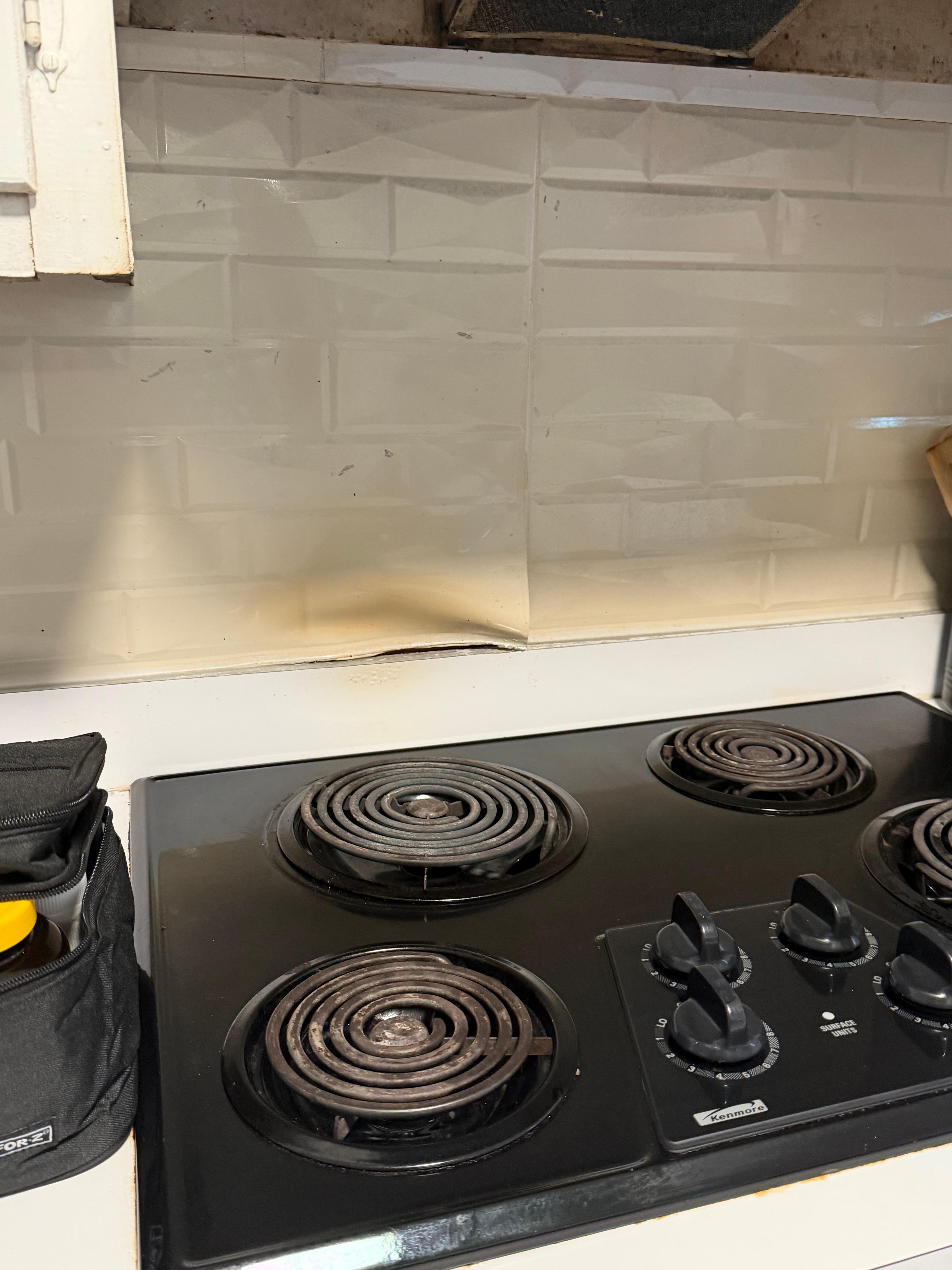 Peeling behind stove 