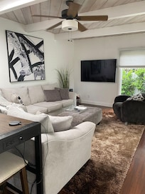 Comfy living room with a wall of sliding glass doors to admire the greenery