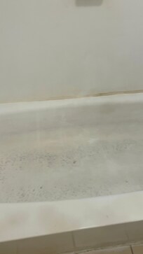 The walls and tub were brown black and yellow. The shower curtain was black and yellow