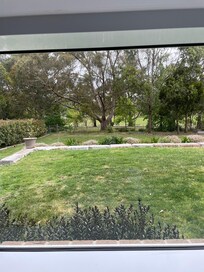 View from kitchen and other shared areas across backyard to oval adjacent.