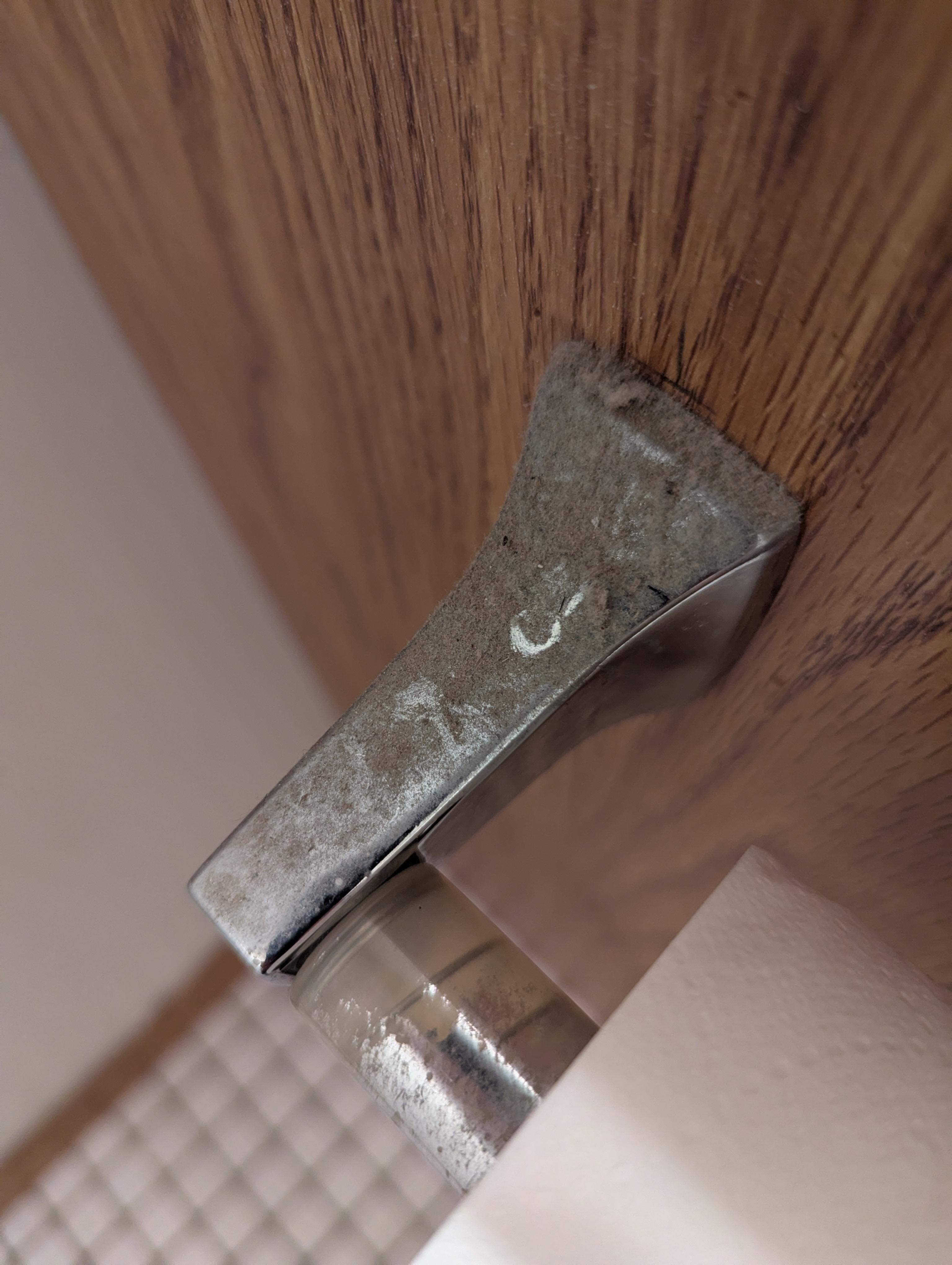Dust buildup on toilet paper roll holder 