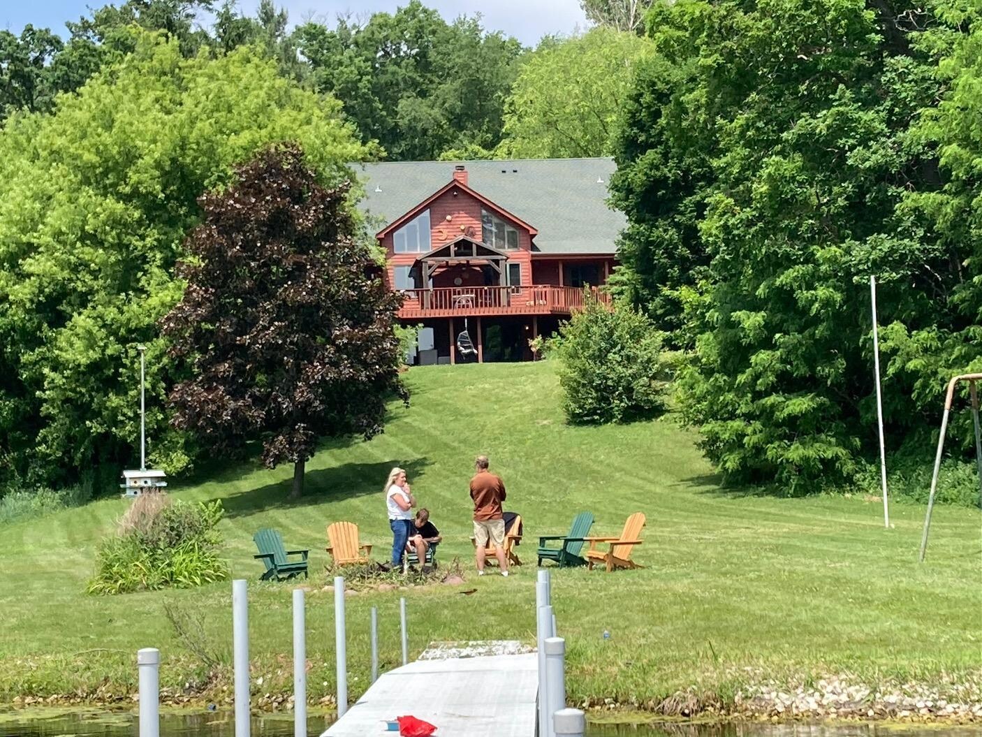 View from pier of back of home! Fire pit in foreground with chairs.