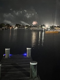Jetty in front of house with fireworks.