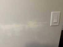 One of many dings and scratches in room wall.