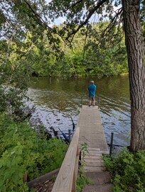 Husband fishing in bay from dock