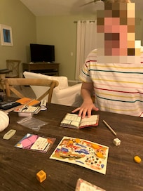 Sitting at dining table playing games, see living area behind.