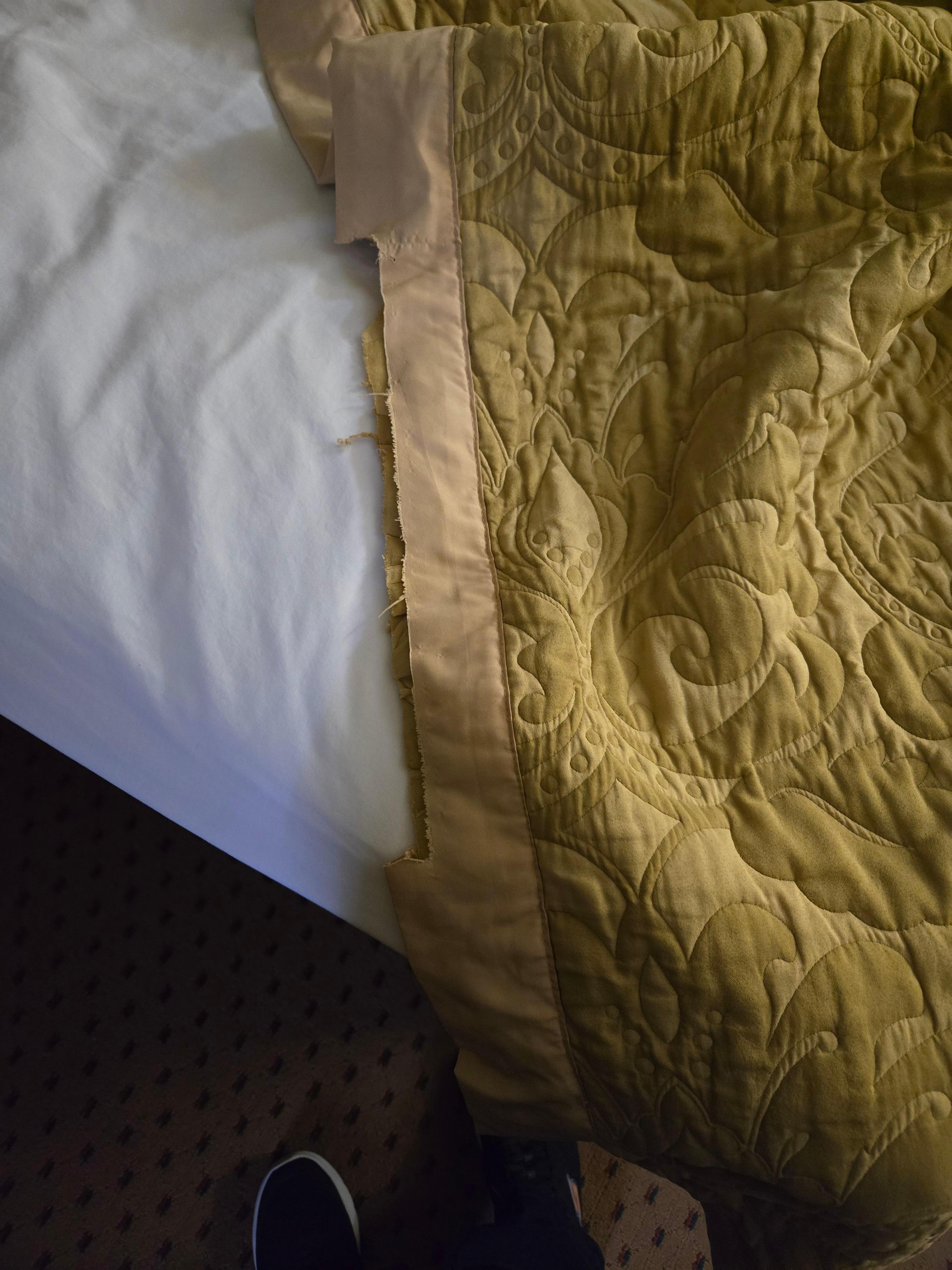 Gold satin spread with the binding torn. Easily 15 years old